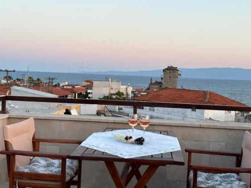 a table with two glasses of wine on a balcony at Yulia Luxury Apartments in Ouranoupoli