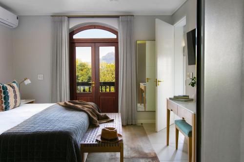 a bedroom with a bed and a door with a window at De Zalze Lodge in Stellenbosch