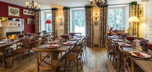 uma sala de jantar com mesas longas e cadeiras em Historic Hotel du Pillon em Les Diablerets