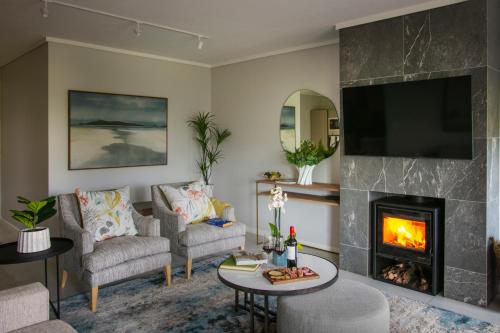 a living room with a fireplace and a tv at De Zalze Lodge in Stellenbosch