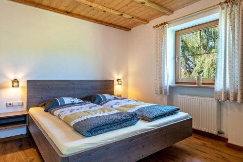 a bedroom with a bed with a wooden headboard and a window at Mongaduierhof Apt Latemar in Umes