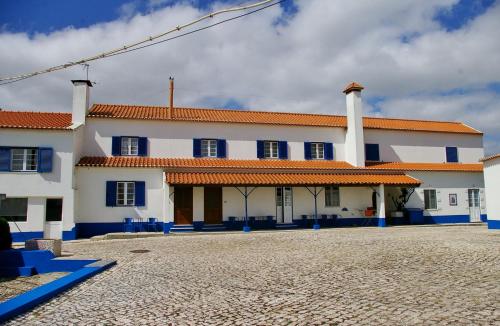 a large white building with blue chairs in front of it at Casal Alentejano in Sintra
