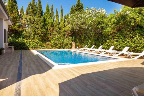 a swimming pool with lounge chairs and a swimming pool at Villa Diagonal in Can Picafort