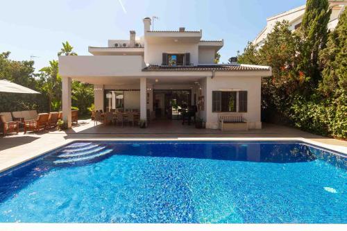 a villa with a swimming pool in front of a house at Villa Diagonal in Can Picafort
