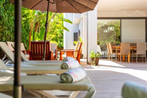 a patio with a table with an umbrella and chairs at Villa Diagonal in Can Picafort