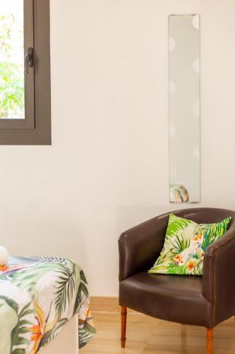 a brown leather chair in a living room with a pillow at Villa Diagonal in Can Picafort