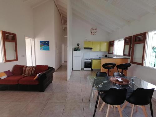 ein Wohnzimmer mit einem Sofa und einem Tisch in der Unterkunft La villa karukera in Sainte-Rose