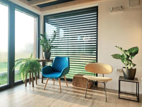 a room with two chairs and a window with blinds at Small house in a nature park in Log pri Brezovici