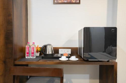 a tv sitting on a wooden table next to a microwave at Hotel Naman in Udaipur