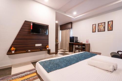 a bedroom with a bed and a flat screen tv at Hotel Naman in Udaipur