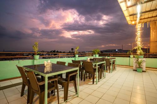 a restaurant with tables and chairs on a roof at Hotel Naman in Udaipur