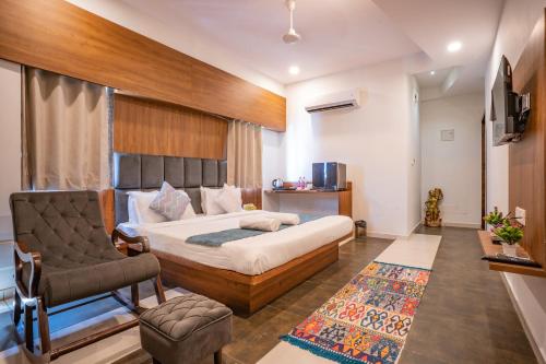a bedroom with a bed and a chair and a couch at Hotel Naman in Udaipur