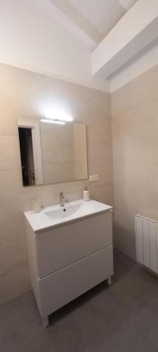 a bathroom with a white sink and a mirror at Apartamentos en Baztan HIRU KABI, BAGA 
