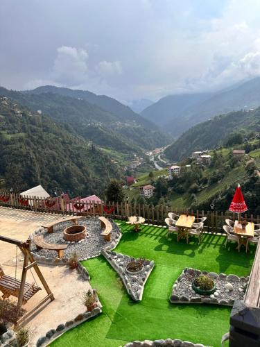 a garden with a view of a valley with mountains at DELLA SUİT BUNGALOW in Çamlıhemşin