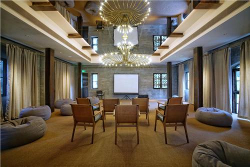 a large room with chairs and a projection screen at Yangshuo Sugar House in Yangshuo