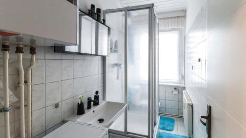 a white bathroom with a sink and a shower at Ferienwohnung mit Tageslichtbad in ländlicher Lage nahe Halle (Saale) in Landsberg