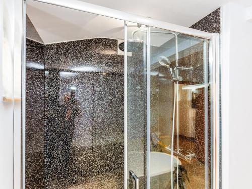 a shower with a glass door with a person taking a picture at Wagtails in Milverton