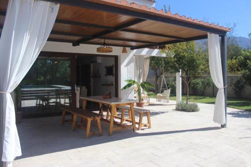 un padiglione con tavolo e panche su un patio di Cortijo Casita Maray a Dúrcal