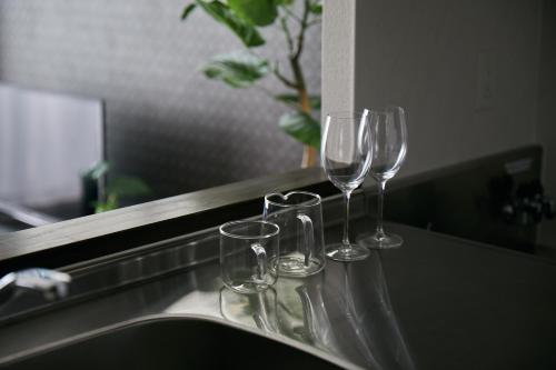 three wine glasses sitting on top of a sink at PINN-N4E2Ⅰ in Sapporo