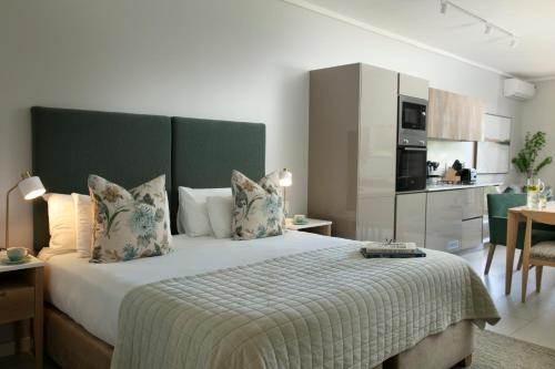 a bedroom with a large bed and a kitchen at De Zalze Lodge in Stellenbosch
