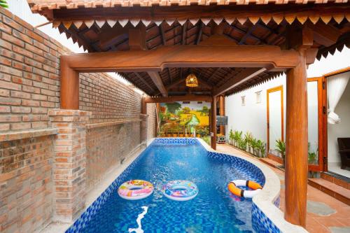 an outdoor swimming pool with a pergola at MY HOME in Hue