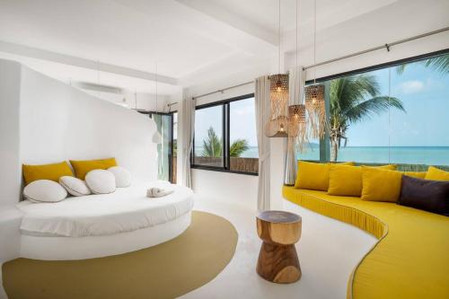 una sala de estar con muebles amarillos y blancos y el océano en Villa Le cerf doré, en Hinkong