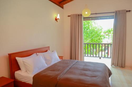 a bedroom with a bed and a large window at IBSON Villa - 02 Hikkaduwa with 4 Bedrooms & Salt Water Swimming Pool in Hikkaduwa