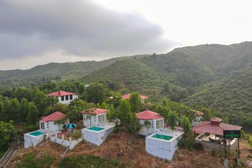 an aerial view of a house with mountains in the background at The HighGarden Resort in Udaipur