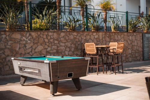 a pool table sitting on a patio with a table and chairs at Lambis Studios & Apartments in Líndos