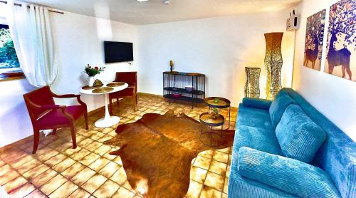 a living room with a blue couch and a table at GastRoom Am Seefeld in Grafing
