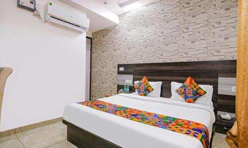 a bedroom with a large white bed with colorful pillows at FabHotel Shyam in Zirakpur