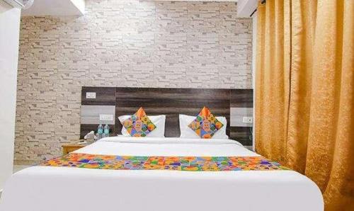 a bedroom with a large bed with a white bedspread at FabHotel Shyam in Zirakpur