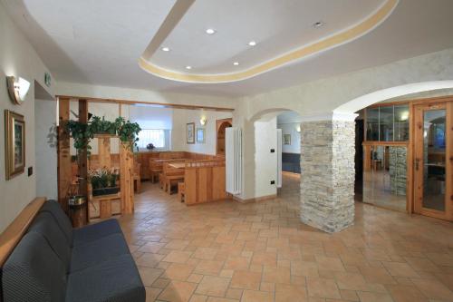 a living room with a couch and a stone pillar at Hotel Stella Alpina in Fai della Paganella
