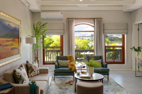 a living room with a couch and two chairs and a table at De Zalze Lodge in Stellenbosch