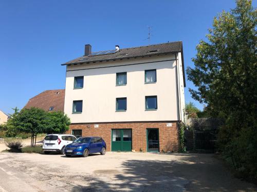 a white building with a car parked in front of it at UNIaparts in Regensburg