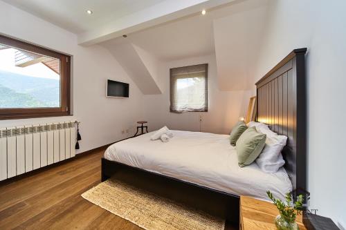 una camera da letto con un letto grande e una finestra di Chalet el Salze lujo con jardin y vistas en la Massana a La Massana