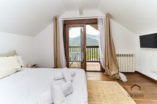 a bedroom with a white bed and a large window at Chalet el Salze in La Massana