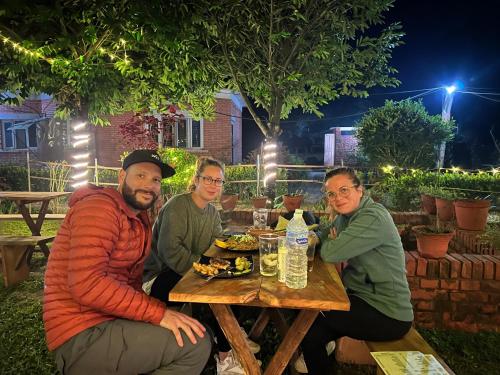 a group of people sitting at a table eating food at Hotel Tharu Garden And Beer Bar in Chitwan