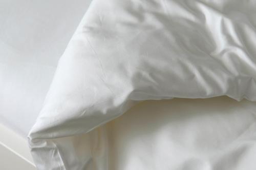 a close up of a bed with white sheets at Gästehaus Hunziker in Zürich