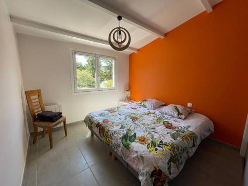 1 dormitorio con paredes de color naranja, 1 cama y 1 silla en Maison, 150 m de la plage, la Tresson,Noirmoutier, en La Guérinière