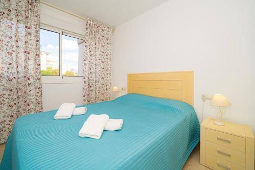 - une chambre avec un lit bleu et 2 serviettes dans l'établissement Estrella 2 2 1a spaniahome, à L'Alfas del Pi