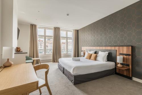 a hotel room with a bed and a desk at Le Phénix Hôtel in Lyon