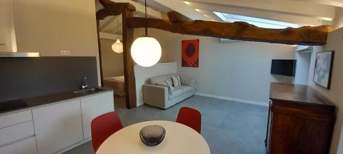 a kitchen with a table and red chairs in a room at Apartamentos en Baztan HIRU KABI, BIGA in Lecároz