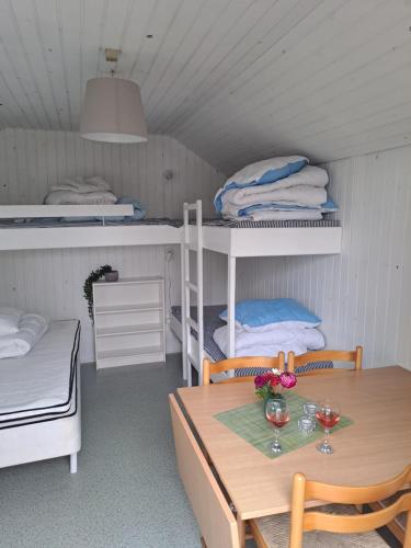 a room with a table and two bunk beds at Hytte - 1 rums hytter in Vig