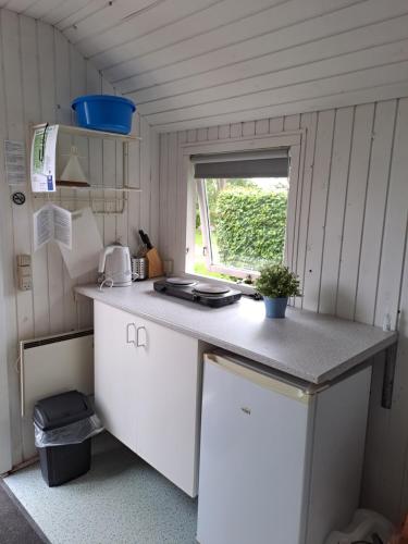 a small kitchen with a counter and a window at Hytte - 1 rums hytter in Vig