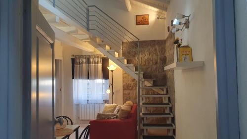 sala de estar con sofá rojo y escalera en Sotto Le Stelle Home - una Baita in città, en Viterbo