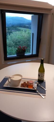 un plato de comida y una botella de vino en una mesa en Apartamentos en Baztan HIRU KABI, BIGA, 