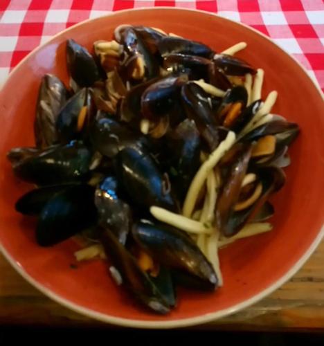 a red bowl of mussels on a table at Heritage Hotel Tragos in Trogir