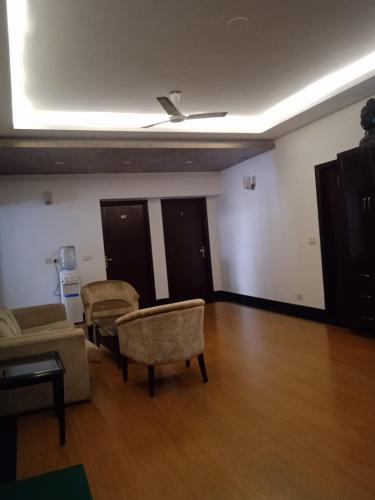 a living room with a couch and chairs and a ceiling at Tavisha Villa Film City Road Dadri Road in Noida