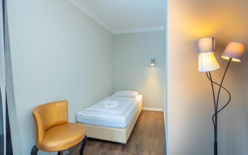 a small room with a bed and a chair at Hotel Calmo in Vienna